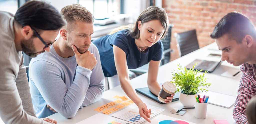 Four people review charts at business meeting